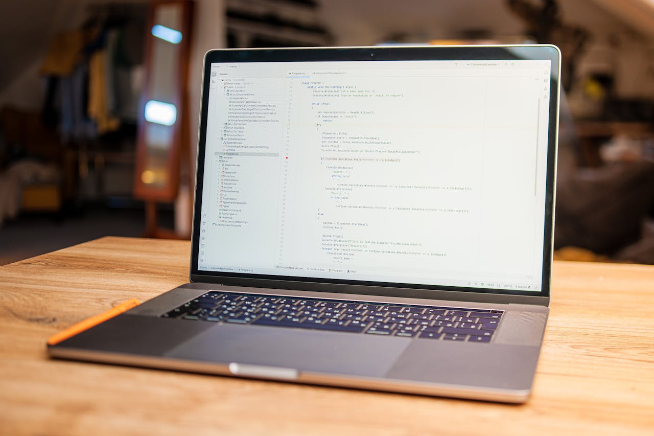 why-choose-us Open laptop with visible code on screen on a wooden desk in a modern, cozy workspace.
