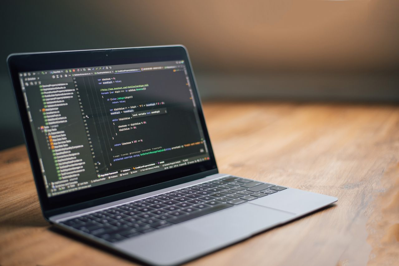 gallery-1 Laptop displaying software code on a wooden table, ideal for tech and programming themes.